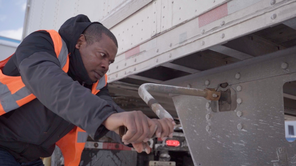 Worker making adjustments to a truck.