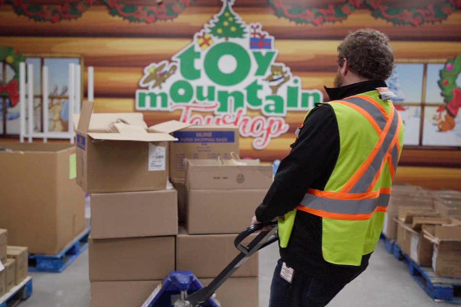 Worker moving pallet of toys.