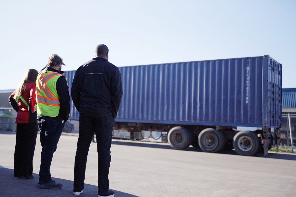 Workers looking at the shipping container Musket Transport is providing.